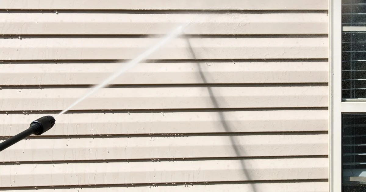 Pressure washing vinyl siding to remove dirt and prepare for cleaning