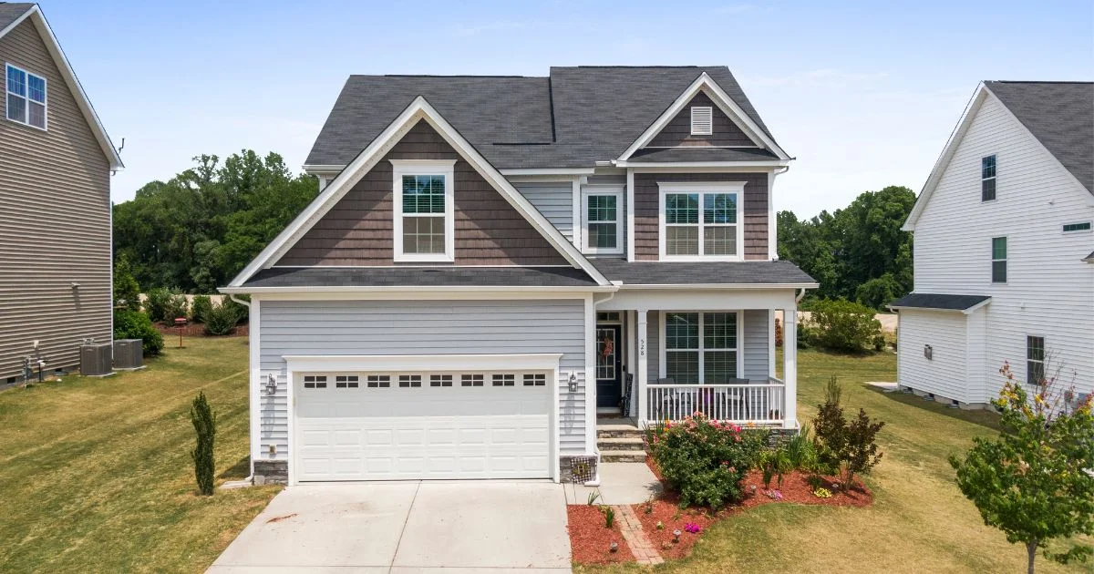 Two-story home with clean vinyl siding and attached garage exterior